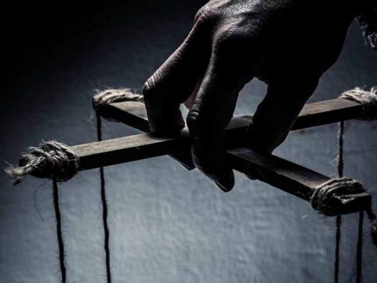 a person holding onto a wooden cross with ropes