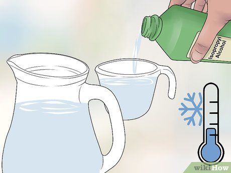 a pitcher pouring water into two mugs