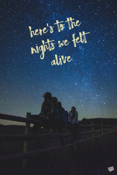 three people sitting on a fence looking up at the night sky with stars in the background