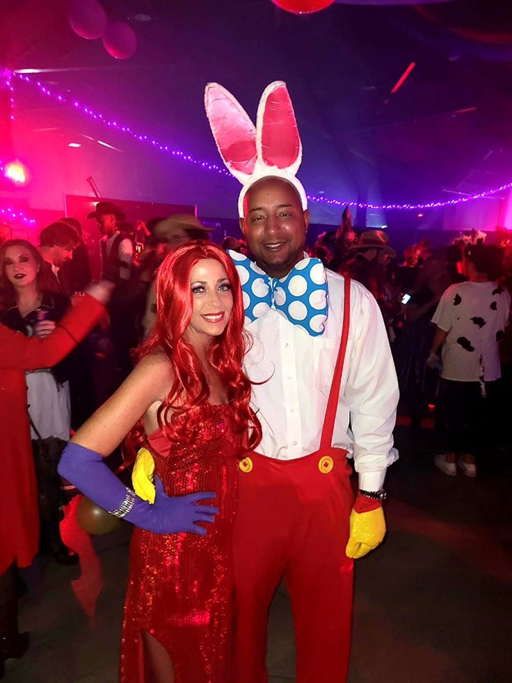 a man and woman dressed up in bunny ears at a party with other people standing around