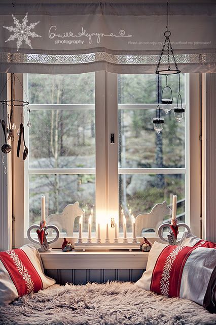 a window seat with candles on it in front of a window