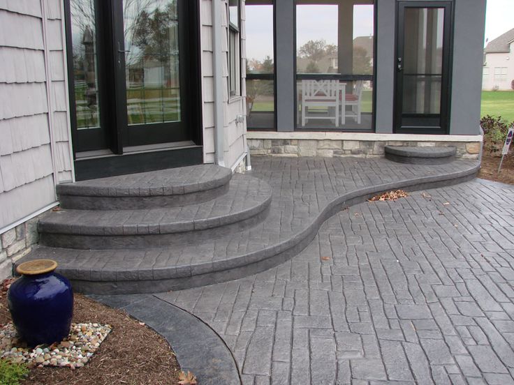 an outdoor patio with steps leading up to the front door