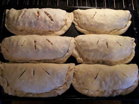 six uncooked pastries sitting on top of an oven