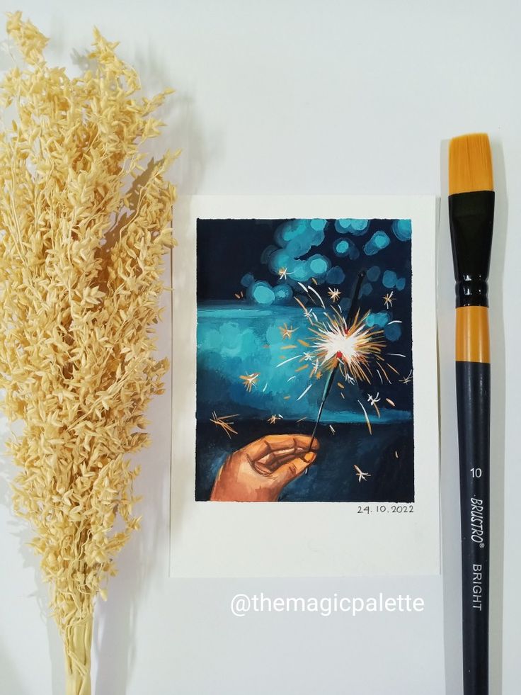 a painting and brush sitting on top of a table next to a piece of paper