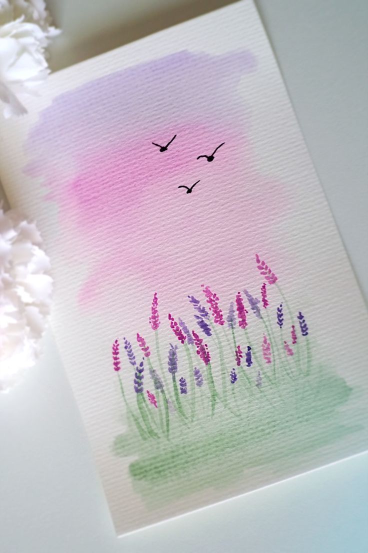 a watercolor painting with birds flying over the grass and flowers on the table next to it