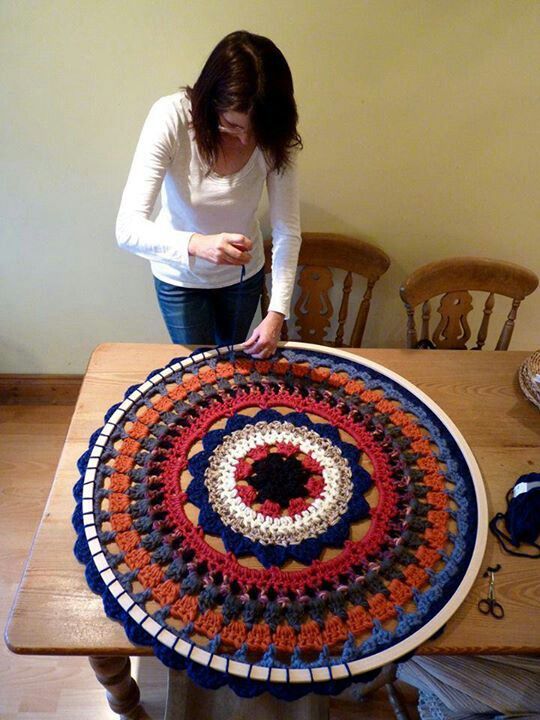 a woman standing in front of a table with a crocheted doily on it