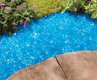 a blue pool with rocks and plants around it