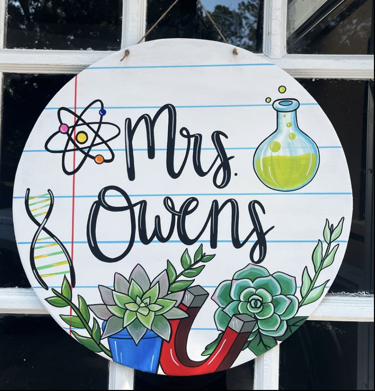 a sign that says, mrs ovens with flowers and an umbrella in front of a window