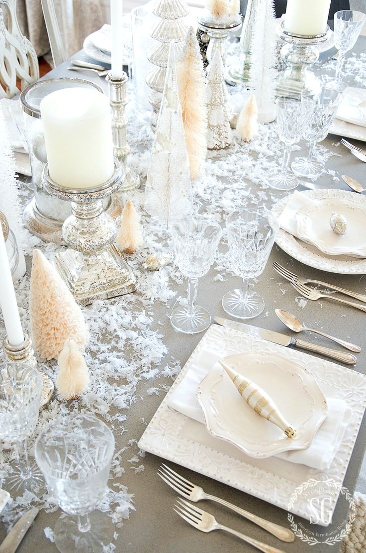 the table is set with silverware and white candles