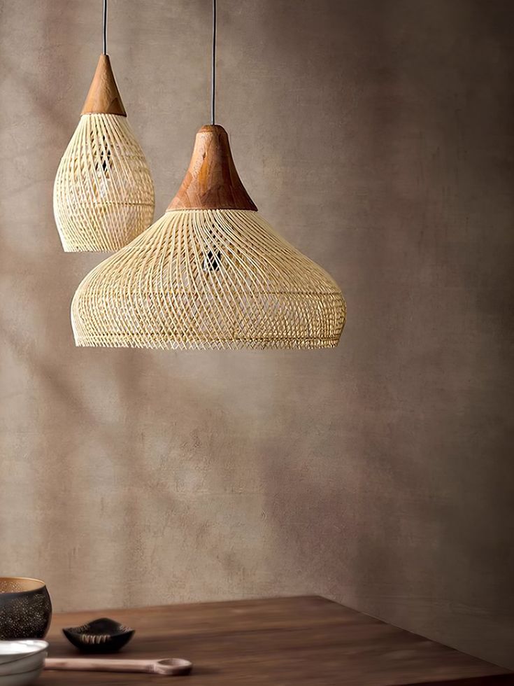 two wooden lamps hanging from the ceiling above a table