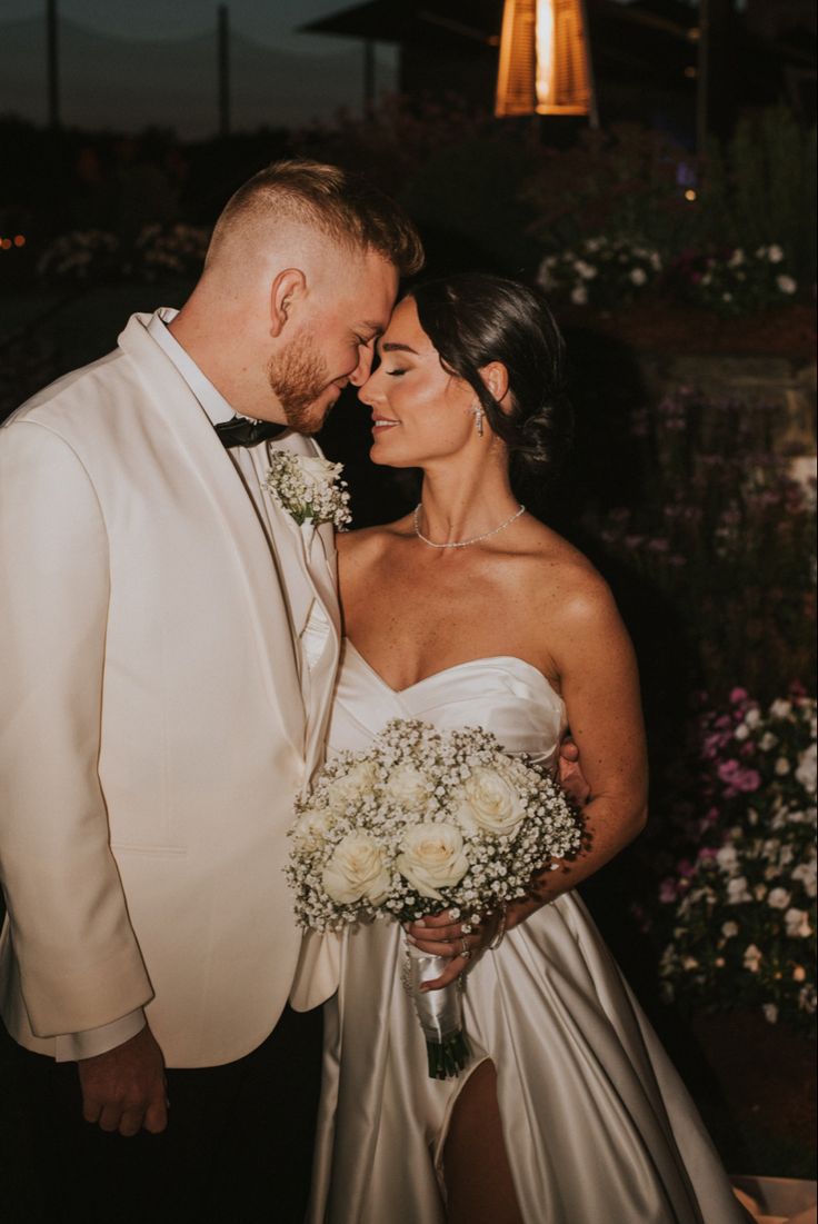 a bride and groom pose for a photo in front of the lights at their wedding