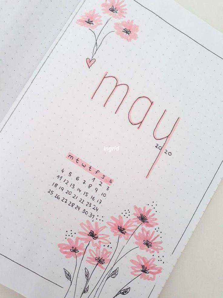 an open notebook with pink flowers and the word may written in cursive writing