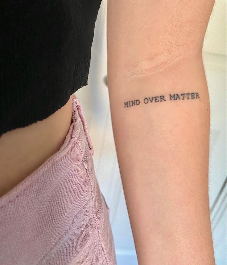 a woman with a tattoo on her arm that says mind over matter in black ink