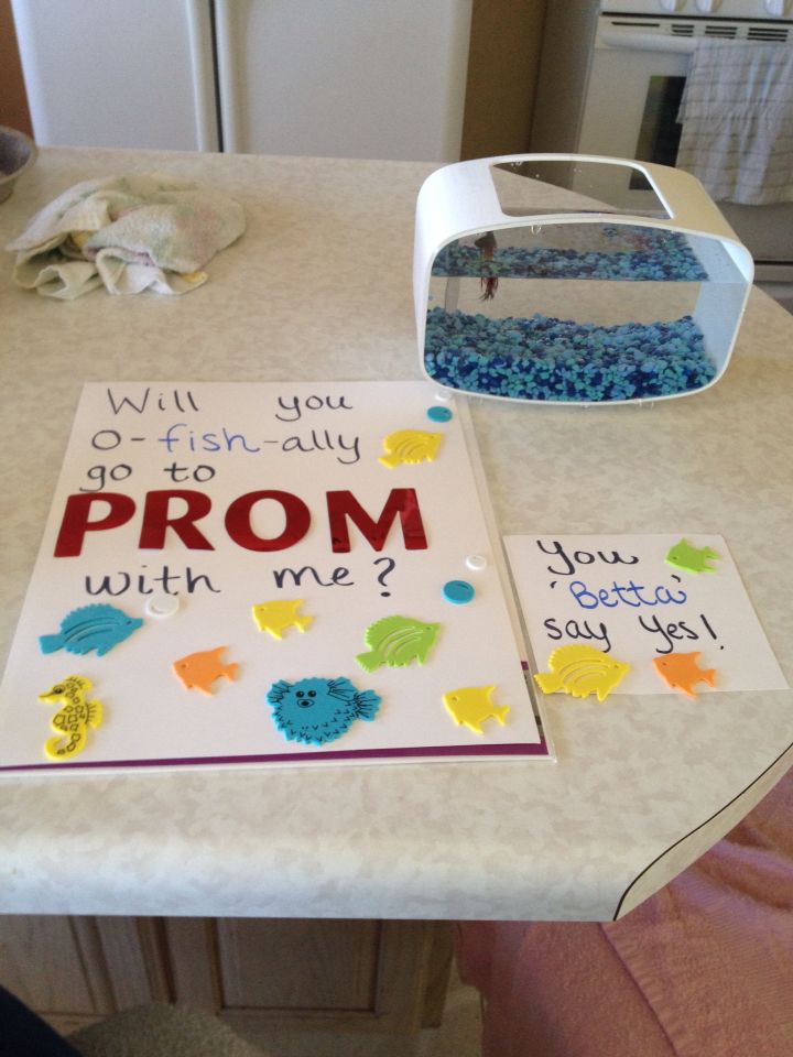 a card that says, will you go to fish ally prom with me? next to a bowl of water