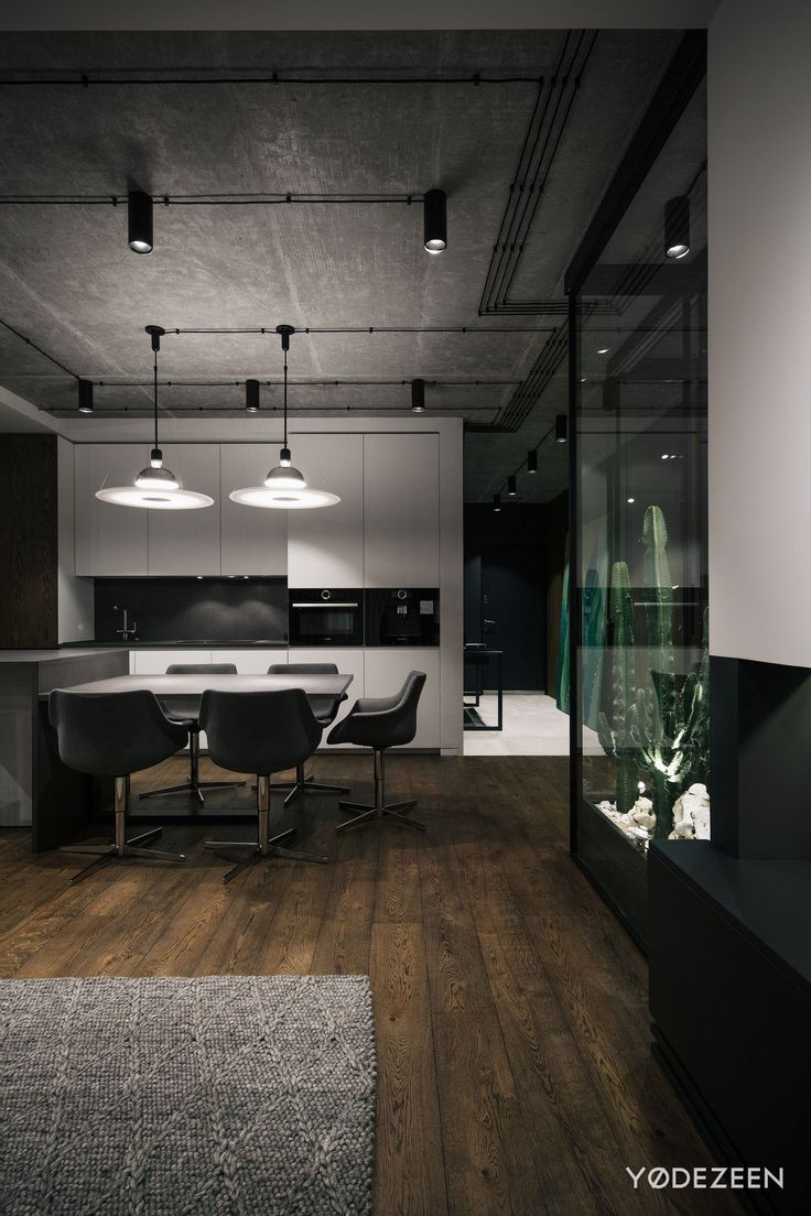 an open concept kitchen and dining area with wood flooring, white walls and ceiling lights