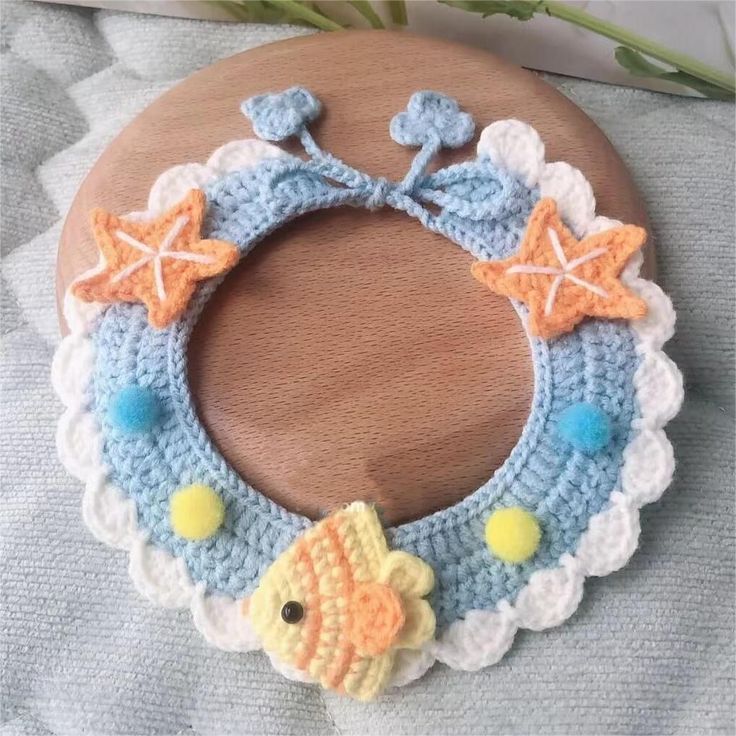 a crocheted bracelet with fish and starfish decorations on it, sitting on a table