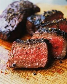 some steaks are sitting on a cutting board