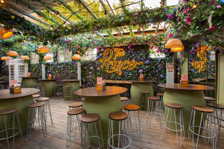 an outdoor restaurant with lots of tables and stools