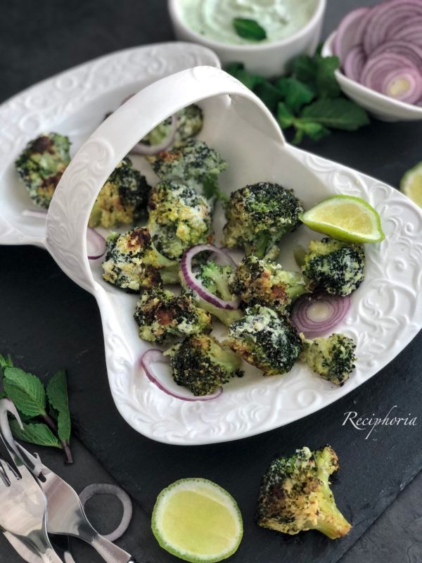 broccoli florets and onions in white serving dishes with lime wedges