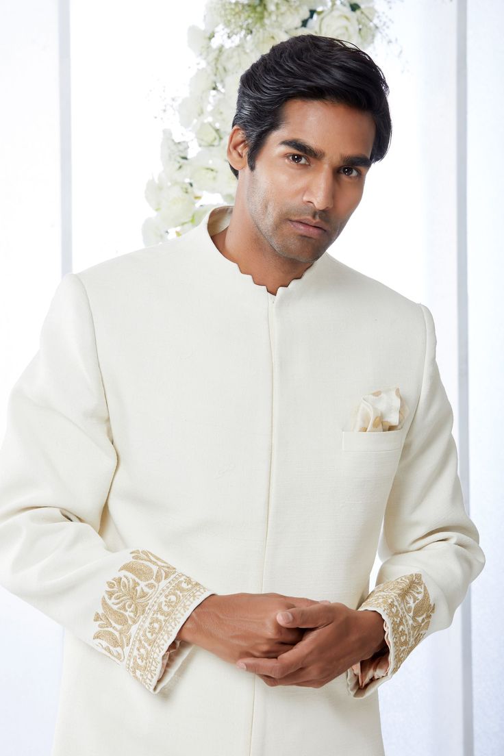 This ivory sherwani set features kiran dori embroidery on the cuffs and a stepper collar detail on a matka silk base. This ensemble is paired with a cotton silk kurta and a stretchable cotton silk trouser. Complimenting footwear is also available.From Seema Gujral's Tuscan Summer collection. DELIVERY TIMEPlease allow 8-12 weeks for your outfit to arrive.FABRIC DETAILSMatka SilkProfessional cleaning only. Cream Sherwani With Chikankari Embroidery And Long Sleeves, Cream Long Sleeve Sherwani With Chikankari Embroidery, Ceremonial Cream Nehru Jacket With Zari Work, Off White Zari Work Sets For Formal Occasions, Traditional Off White Raw Silk Bandhgala, Ceremonial Off White Sets With Resham Embroidery, Traditional Raw Silk Bandhgala In Off White, Cream Bandhgala With Chikankari Embroidery For Transitional Season, Cream Bandhgala With Chikankari Embroidery In Raw Silk