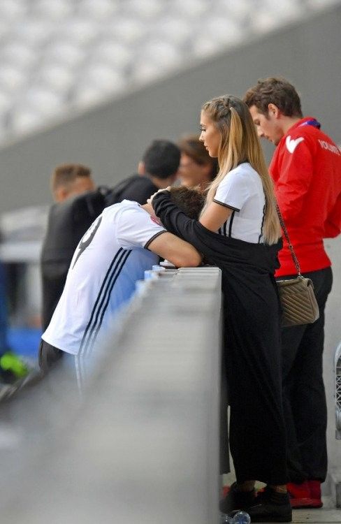 two people sitting on a bench next to each other at an event or sporting event