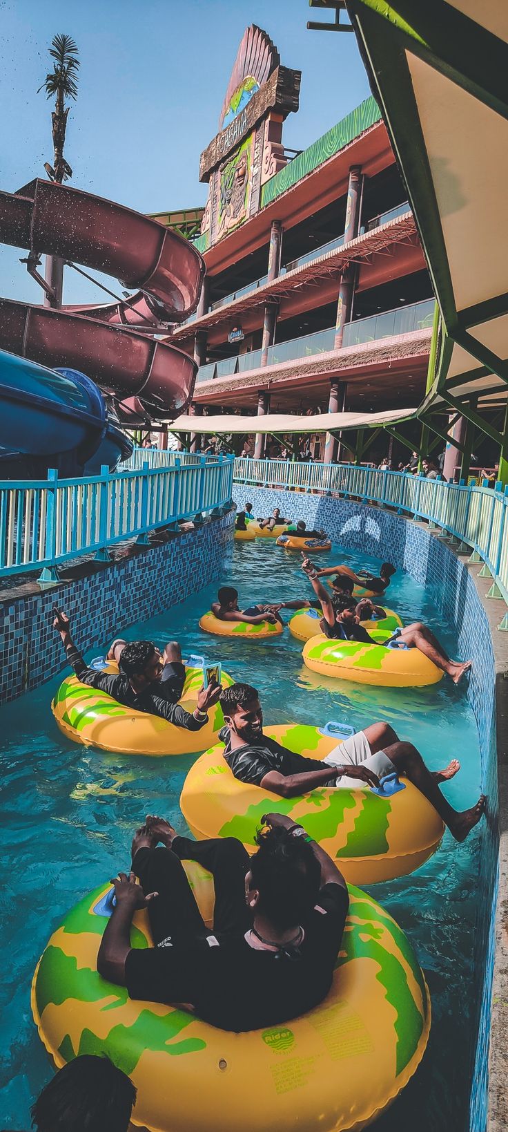 people are floating on inflatable rafts at the water park