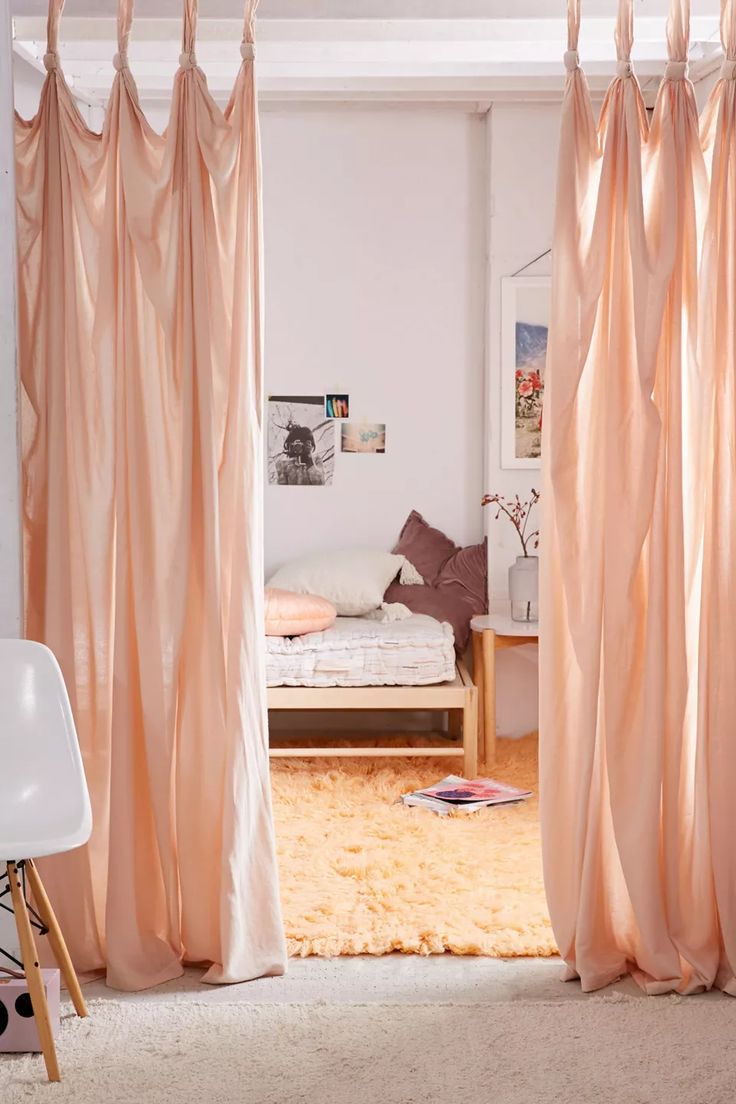 an open door to a bedroom with pink curtains