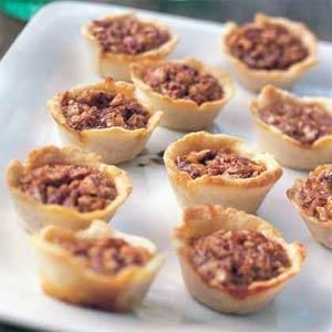 mini pies filled with meat on a white platter, ready to be eaten