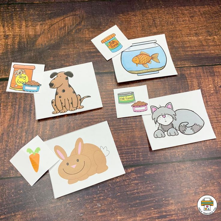 four cards with pictures of animals and fish on them sitting on a wooden table next to each other