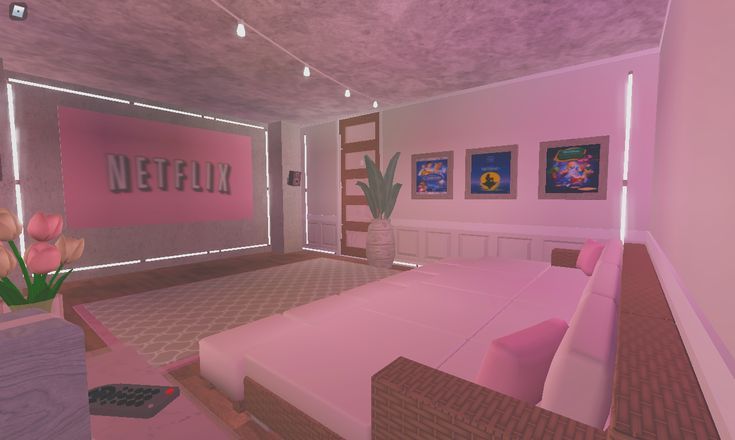 a room with pink furniture and paintings on the walls, including a bed in front of a tv