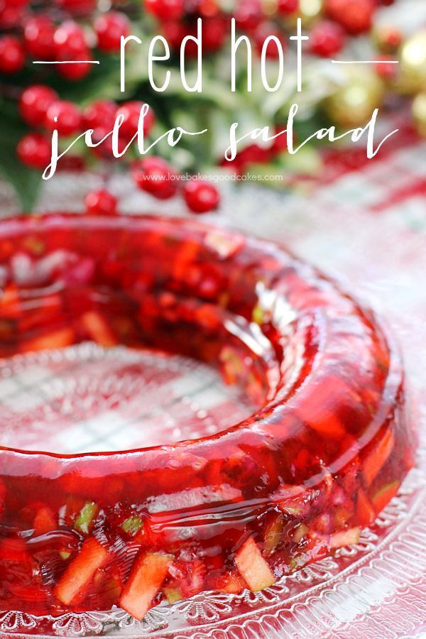 red hot jello spread on a glass cake plate with cranberry sauce in the middle