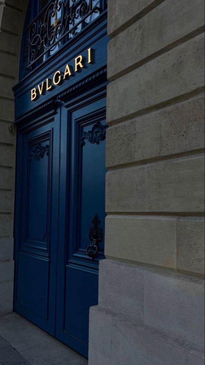 the entrance to an elegant building with blue doors