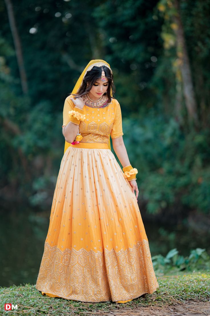 a woman in a yellow dress is posing for the camera with her hands on her hips