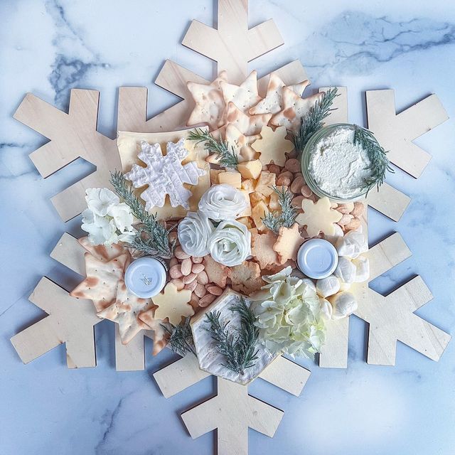 a snowflake made out of cheese and other items on a marble countertop