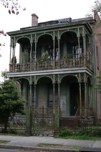 an old house with green trim and balconies