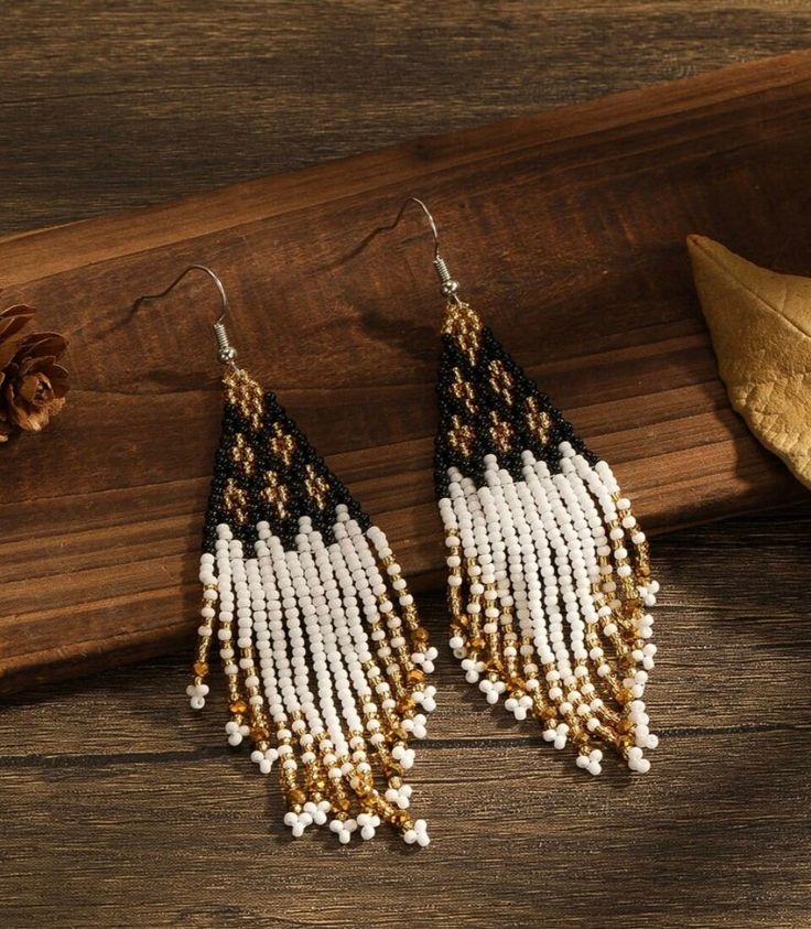 These handmade beaded earrings are a stunning accessory that seamlessly blends elegance with a touch of bohemian flair. Harmonious combination of black, yellow, and gold hues. These colors work together to create a striking contrast and an air of sophistication. The intricate craftsmanship and attention to detail make them a unique and eye-catching addition to any outfit. Approx 4 in.long Black Tassel Drop Earrings With Colorful Beads, Black Bohemian Beaded Earrings With Gold Beads, Bohemian Black Tassel Earrings With Round Beads, Black Bohemian Tassel Earrings With Round Beads, Black Beaded Bohemian Tassel Earrings, Bohemian Black Chandelier Earrings With Colorful Beads, Handmade Beaded Earrings, Handmade Earrings Beaded, Beaded Fringe