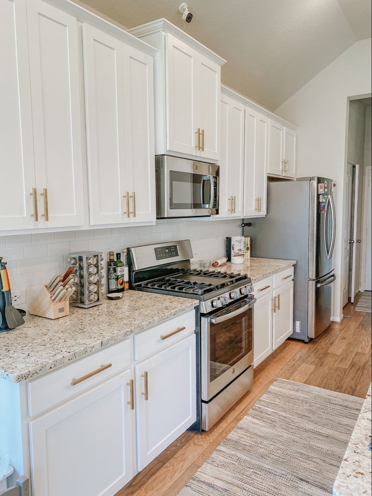 a kitchen with white cabinets and stainless steel appliances