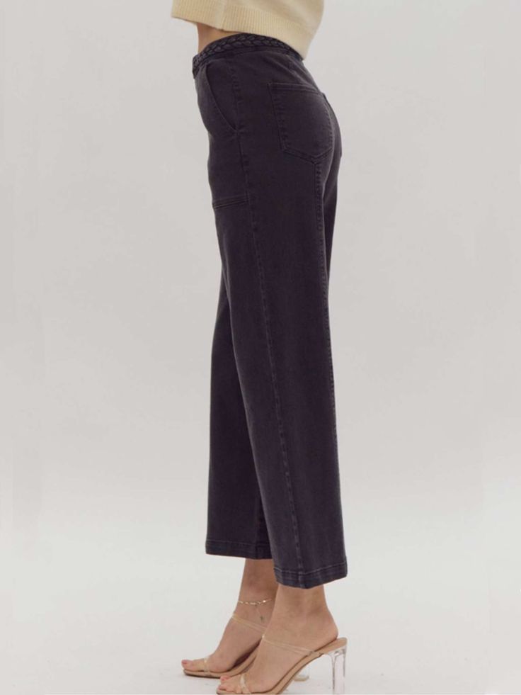 Elevate your style with our versatile and sophisticated high-waisted wide-leg pants. These solid black bottoms feature a unique braided detail at the waist, adding a touch of elegance to a timeless silhouette. The button and zipper closure ensures a secure fit, while the lightweight, woven fabric offers comfort and effortless movement. Designed for versatility, these pants are non-sheer and unlined, making them the perfect choice for both day and night. Pair with your favorite blouse or top for Washed Black Wide-leg Pants For Fall, Chic High Rise Wide Leg Pants With Pockets, Chic High Rise Washed Black Bottoms, Elegant High-rise Wide Leg Pants For Workwear, Versatile Black Cropped Leg Bottoms, Washed Black Cropped Leg Bottoms For Fall, Fall Wide Leg Washed Black Pants, Chic Cropped Wide Leg Pants With Elastic Waistband, Chic Cropped Wide Leg Pants With Relaxed Fit