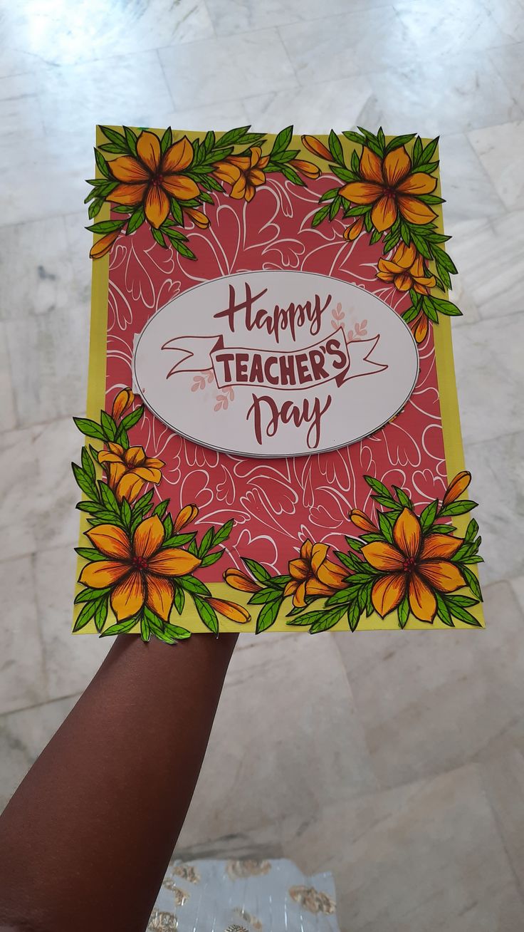 a hand holding up a card that says happy teachers day with yellow flowers on it