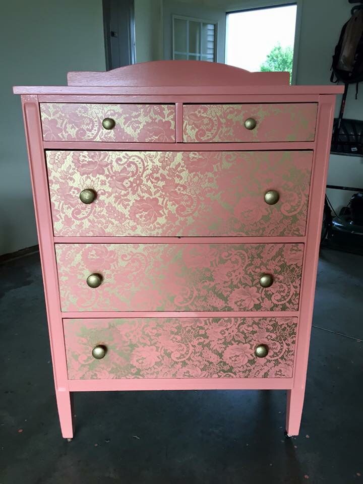 a pink and gold dresser in a room