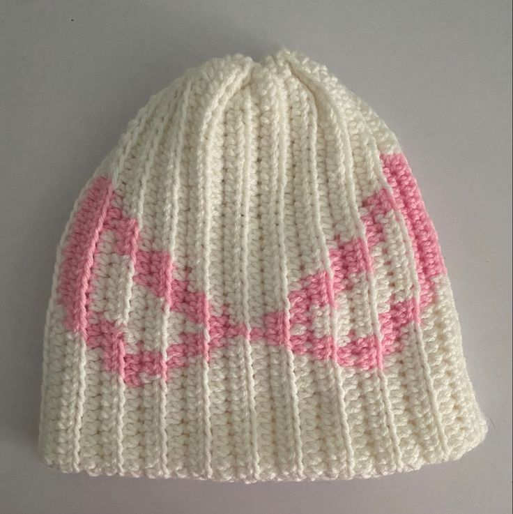 a white and pink knitted beanie hat with the word love on it's side