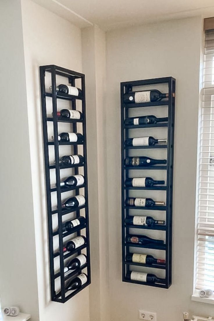 two black metal racks holding wine bottles in a bathroom