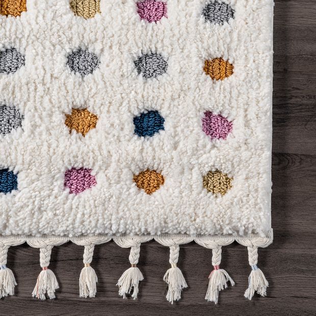 a multicolored rug with tassels and fringes on the bottom is laying on a wooden floor