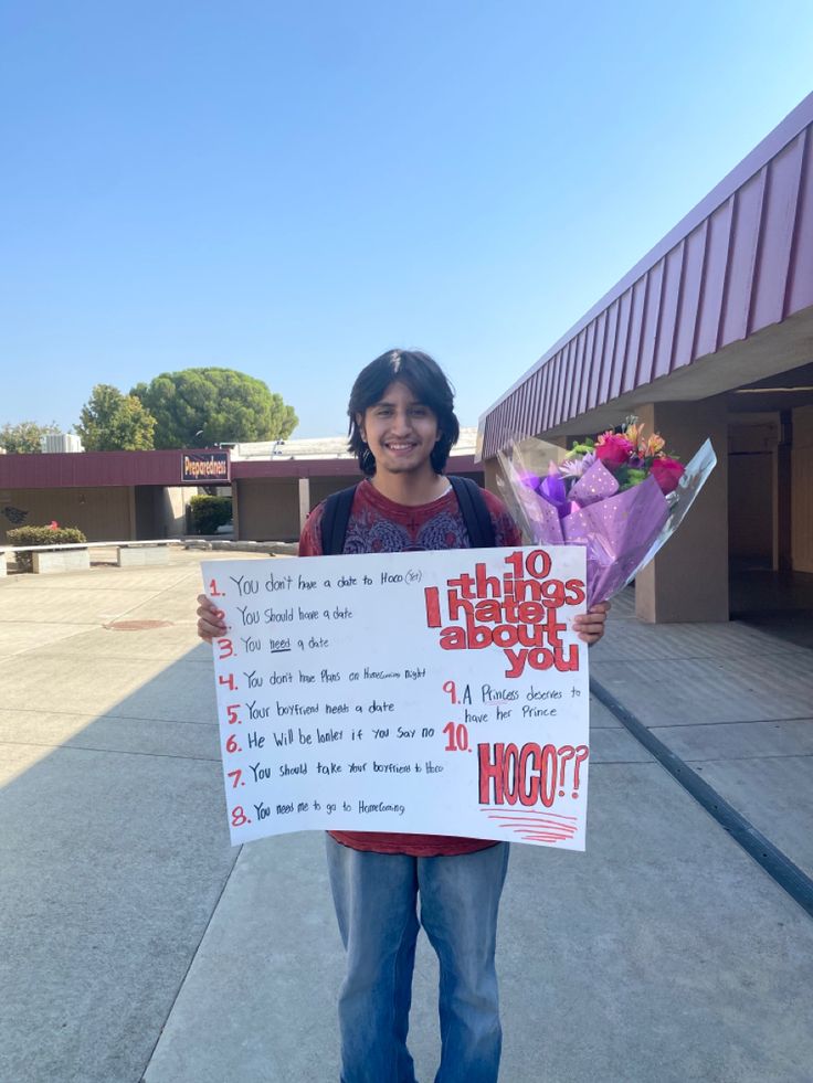 a woman holding up a sign with flowers on it