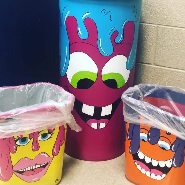 three trash cans with faces painted on them and plastic wrap around the edges, sitting next to each other