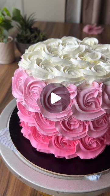 a cake with pink and white frosting roses on it