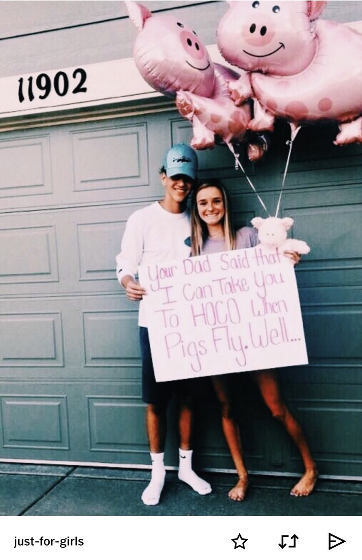 two people standing in front of a garage holding up pink balloons and a sign that says, your dad said he'd like to take you to hoo