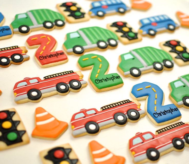 decorated cookies with cars, trucks and cones are on a table next to each other