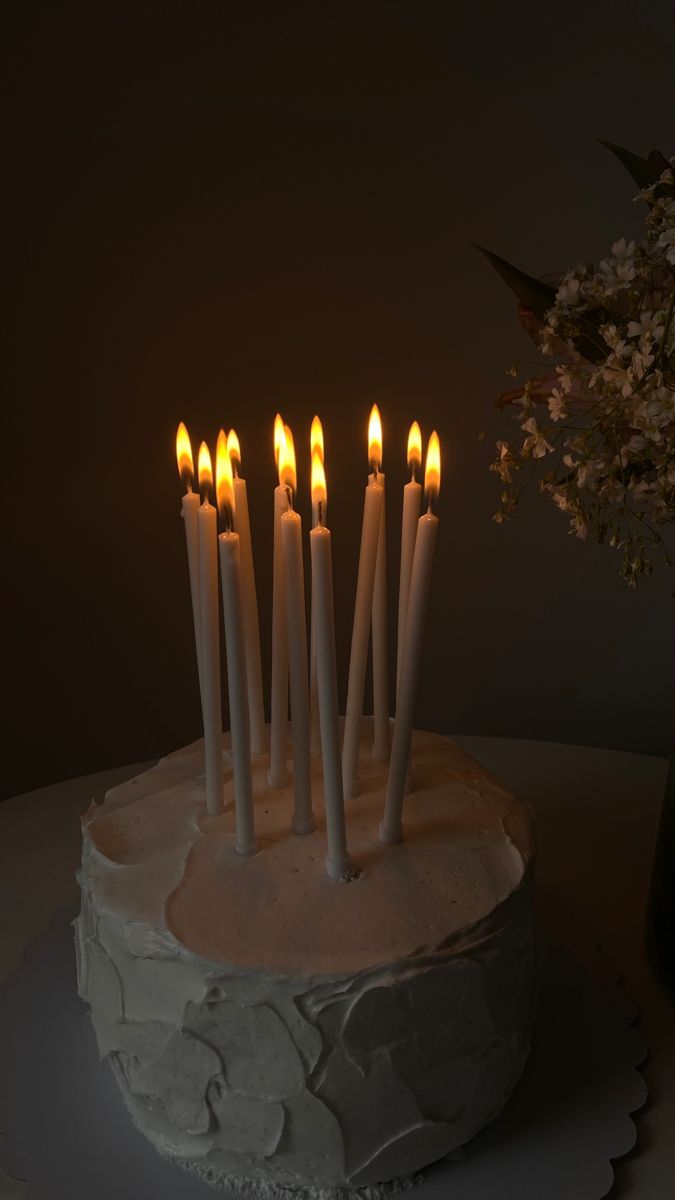 a white cake topped with lots of lit candles