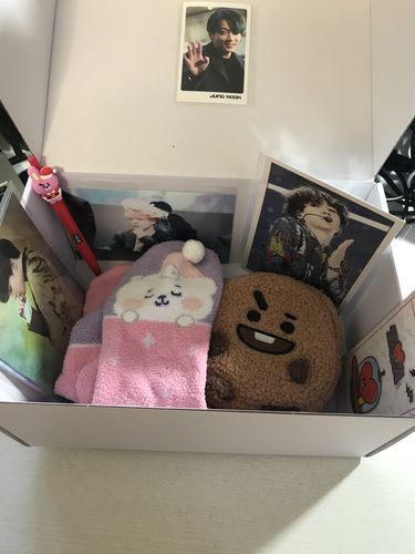 an open box filled with pictures and stuffed animals on top of a white countertop